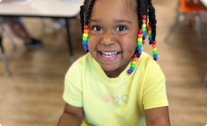 Happy toddler smiling during classroom activities at Ardent Preschool & Daycare, enjoying a fun and engaging learning environment