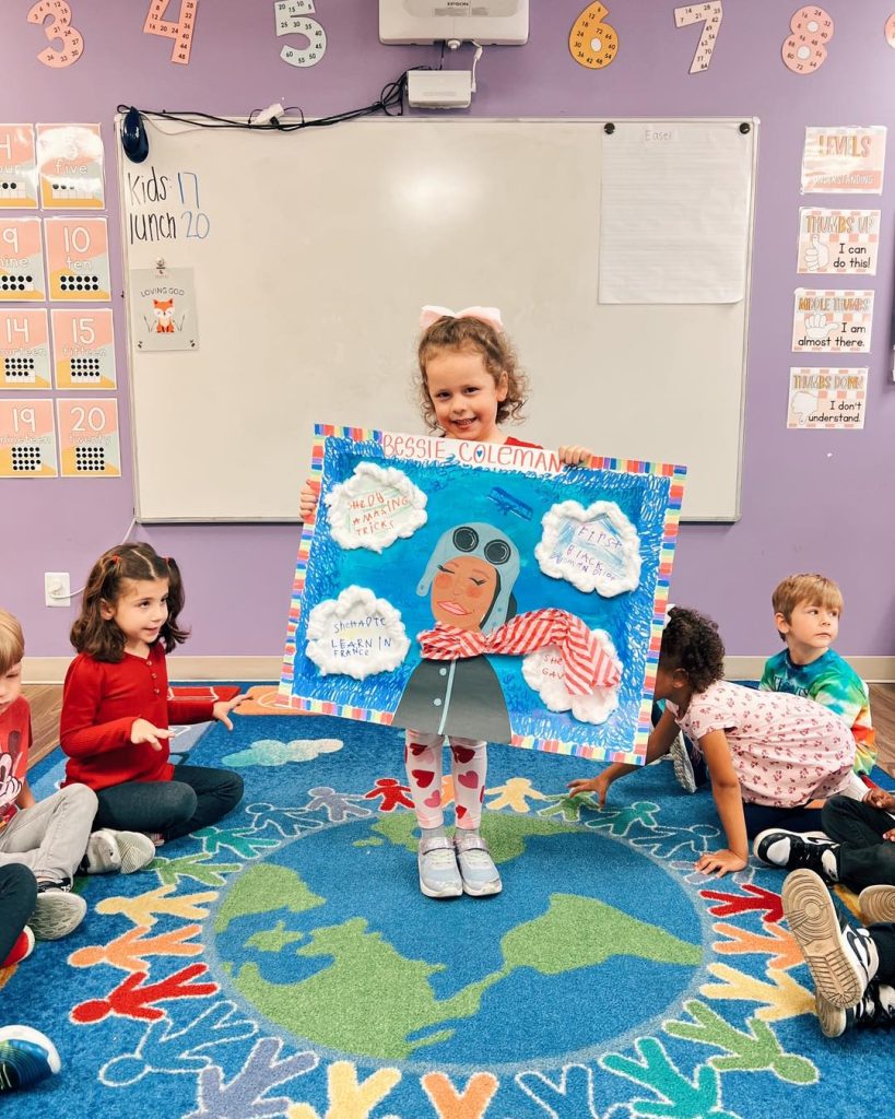 Preschooler at Ardent Preschool & Daycare presenting her book report to the class, building confidence and social development through early public speaking.