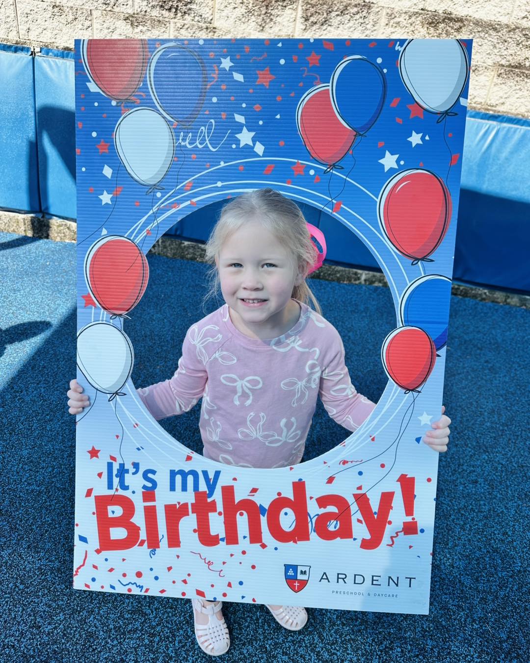 Little girl holding happy birthday sign during birthday celebration at Ardent Preschool & Daycare
