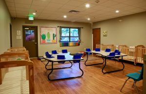 Cribs and feeding seats in the infant room at Ardent Trace Crossings childcare center in Hoover